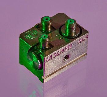 A grey rectangular cubed A/36 accelerometer shot in a purple background 