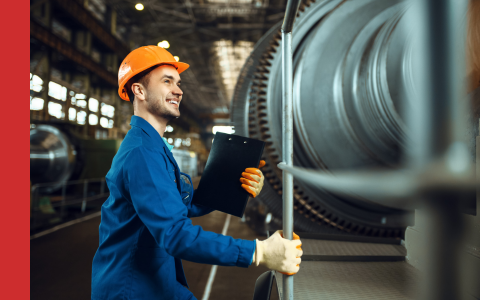 Power station engineer standing next to a turbine