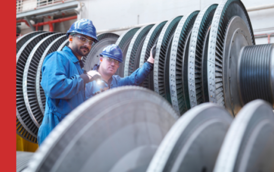 Engineers on power station monitoring machinery