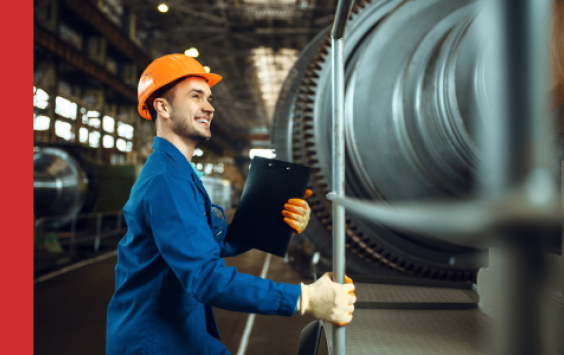 Power station engineer standing next to a turbine
